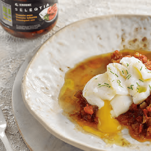 Láminas de bacalao con pimientos verdes, tomates y huevo poché