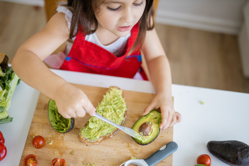 Niña comiendo aguacate